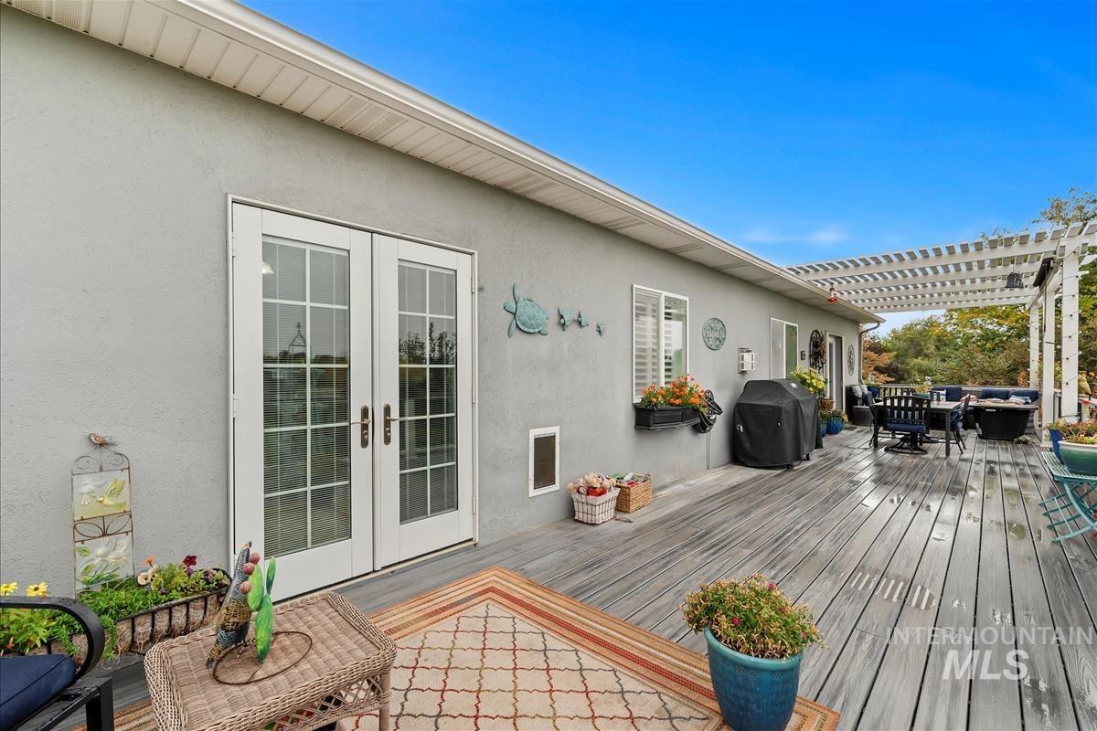 Wooden deck featuring an outdoor living space, a grill, outdoor dining space, and french doors
