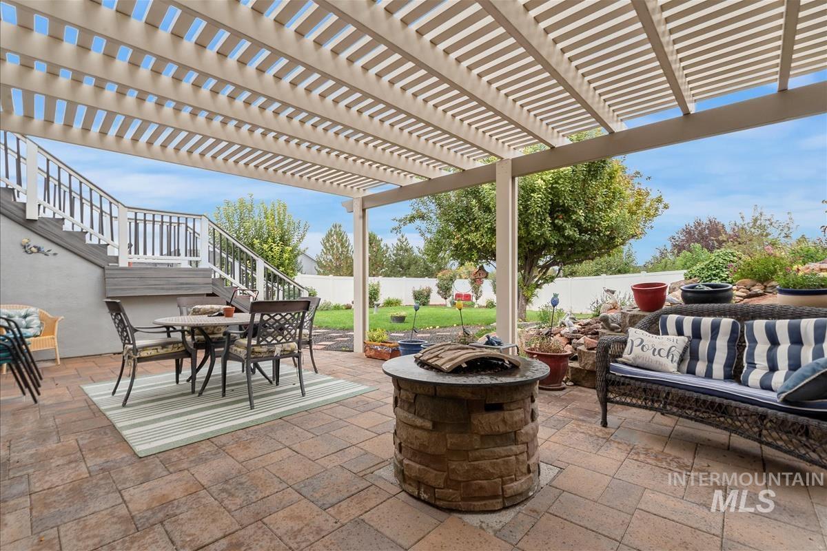 Fenced backyard featuring a patio, outdoor dining area, a pergola, and an outdoor fire pit