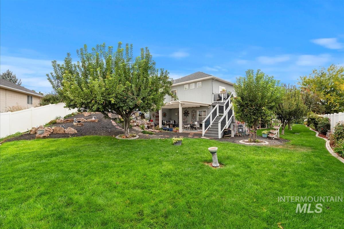 Rear view of house featuring stairway, a patio, and a wooden deck