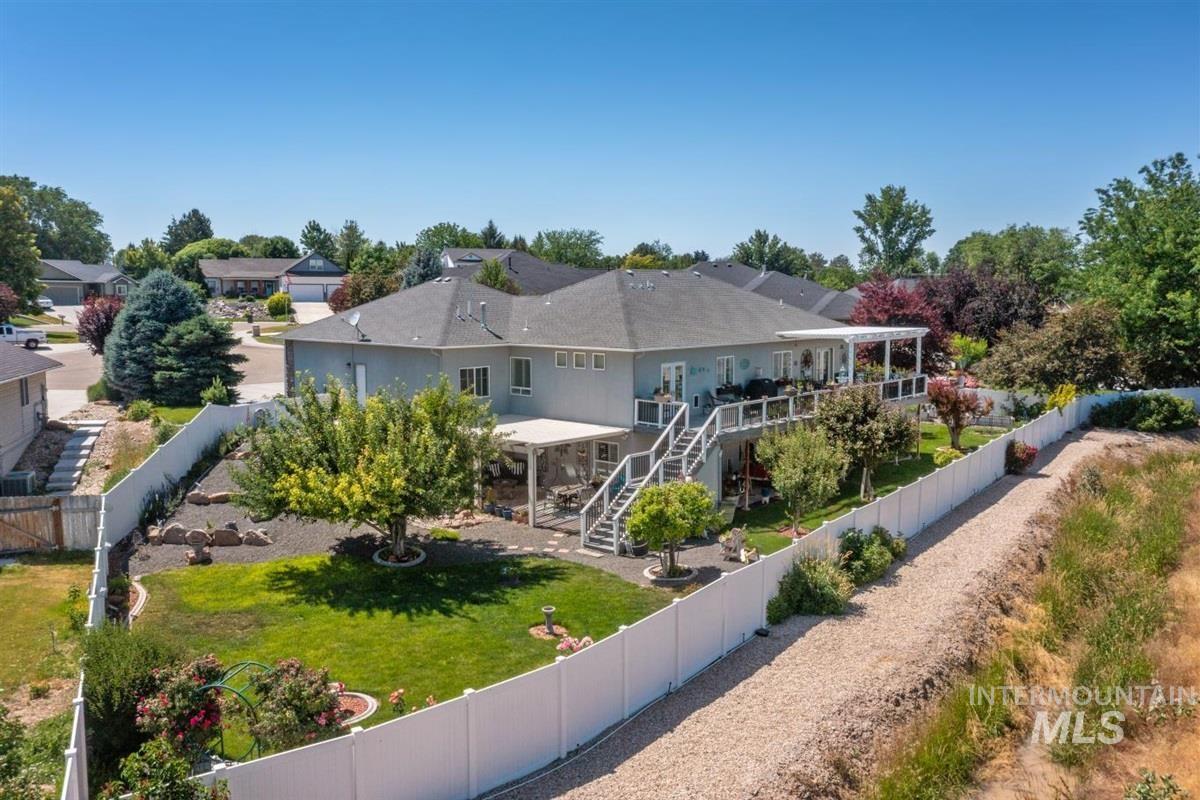 Back of property with a fenced backyard, stairway, and a deck