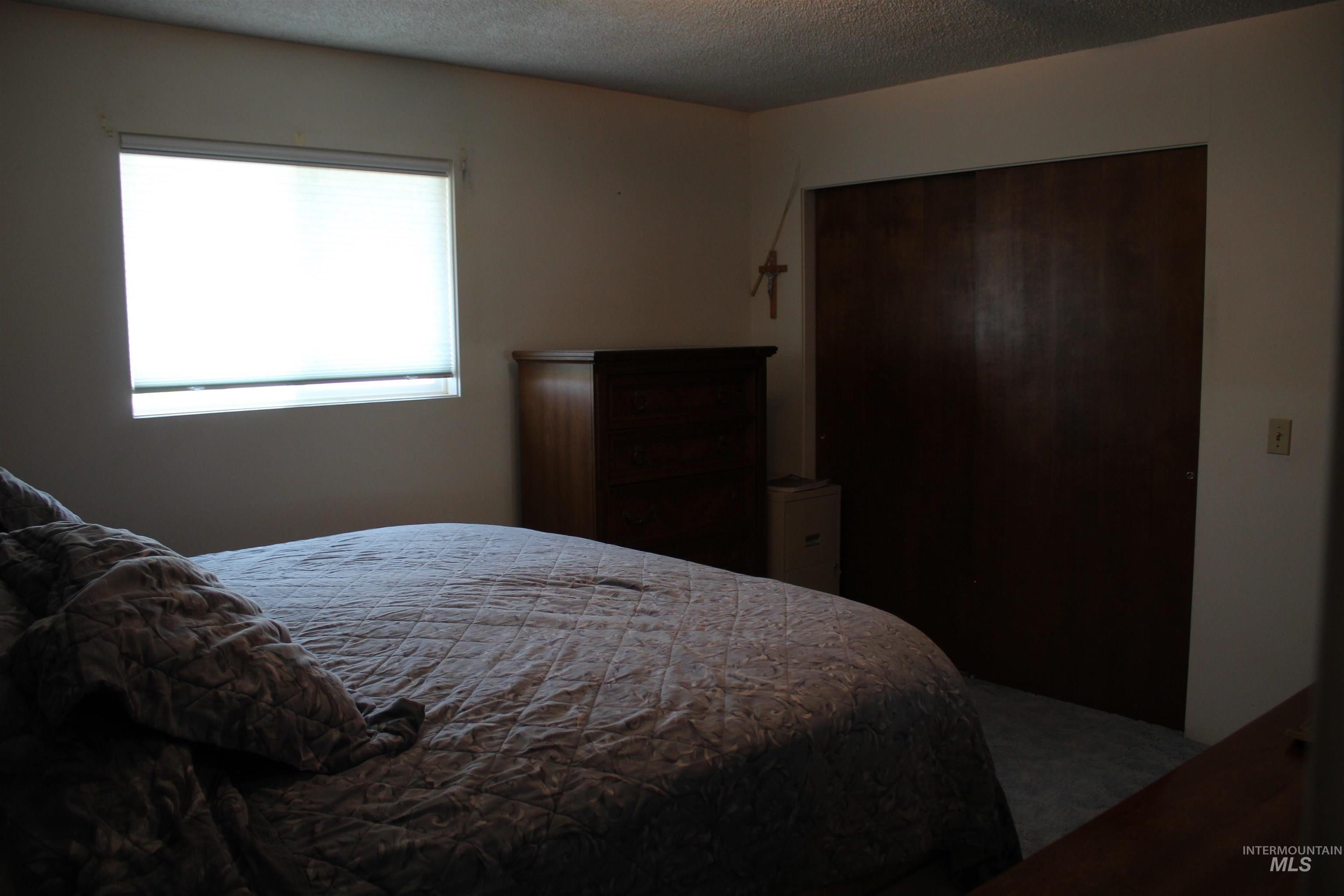 Carpeted bedroom featuring a textured ceiling