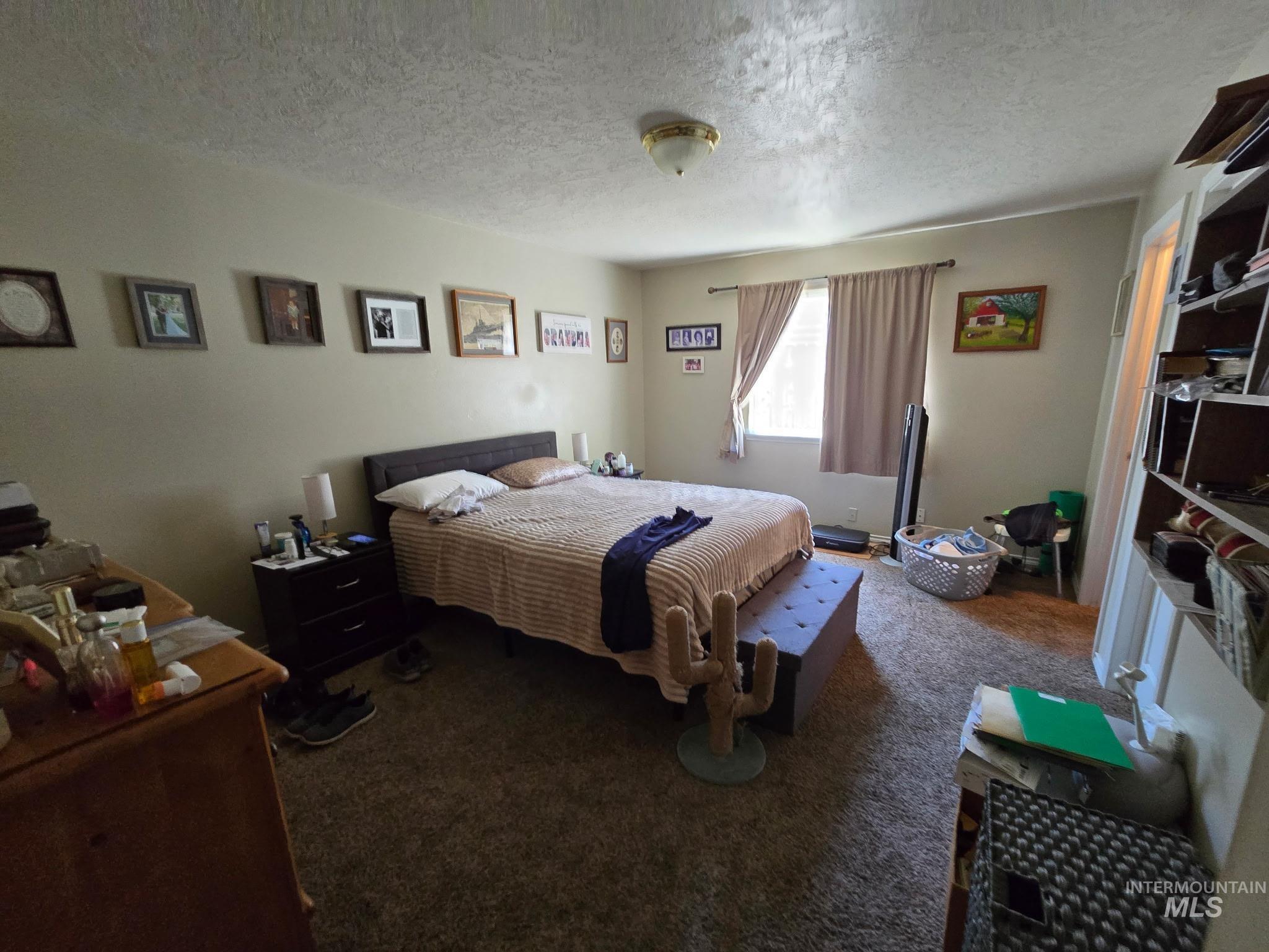 Carpeted bedroom with a textured ceiling