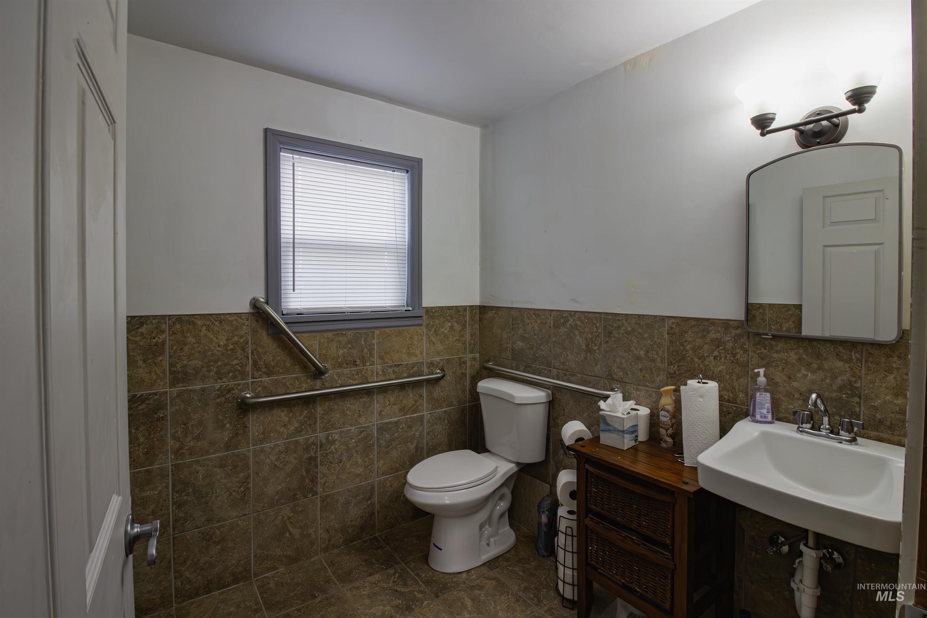 Bathroom featuring tile walls and a wainscoted wall