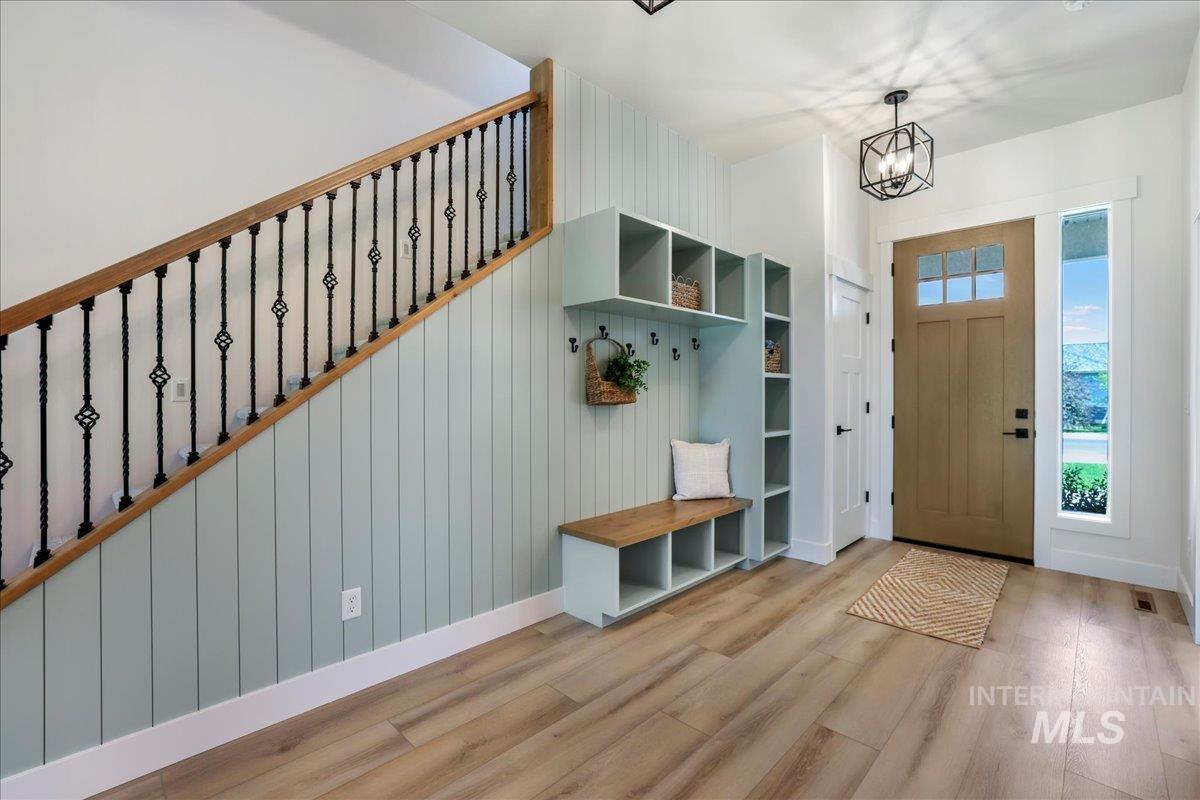 Mudroom featuring wood finished floors and a chandelier