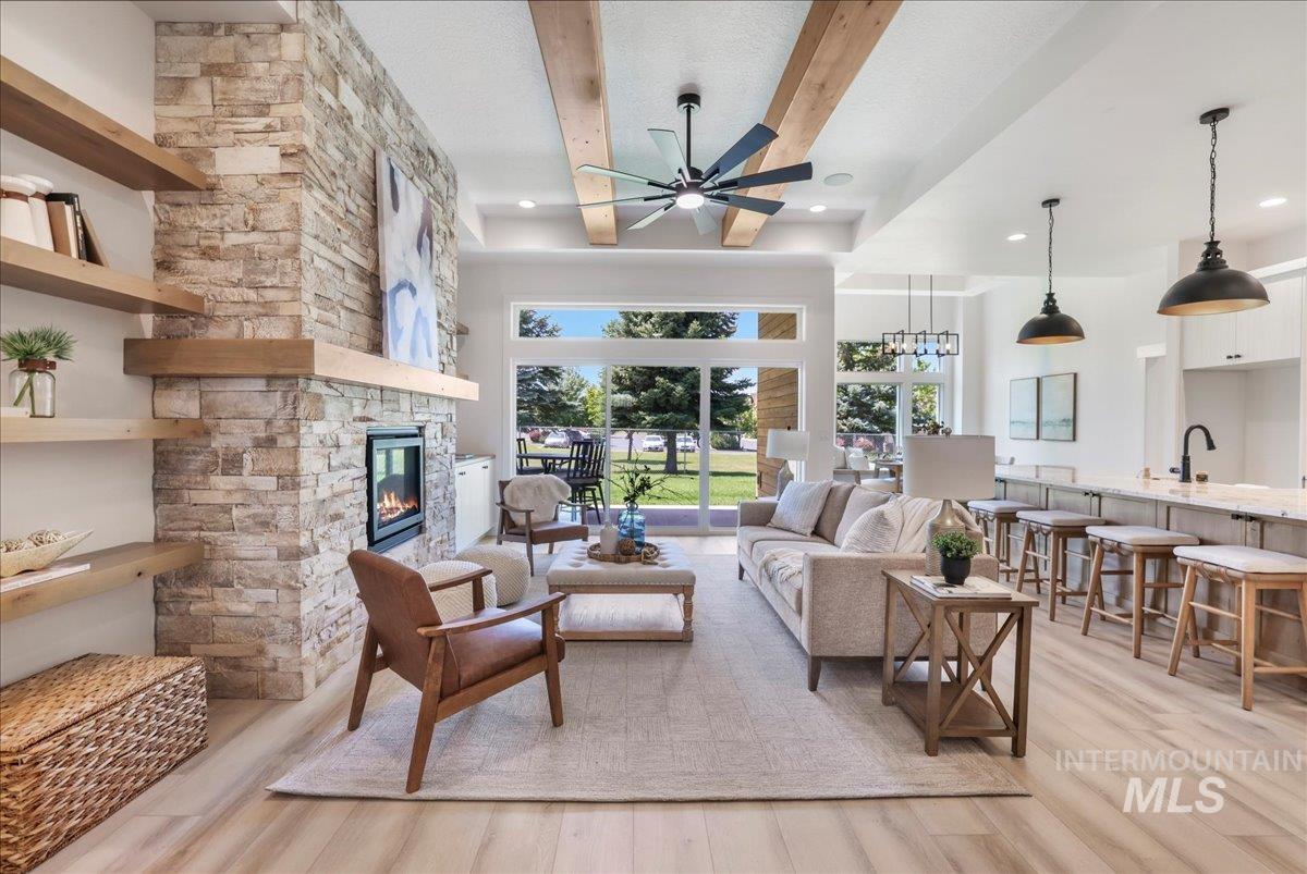 Living room featuring ceiling fan, light wood-type flooring, a fireplace, healthy amount of natural light, and recessed lighting