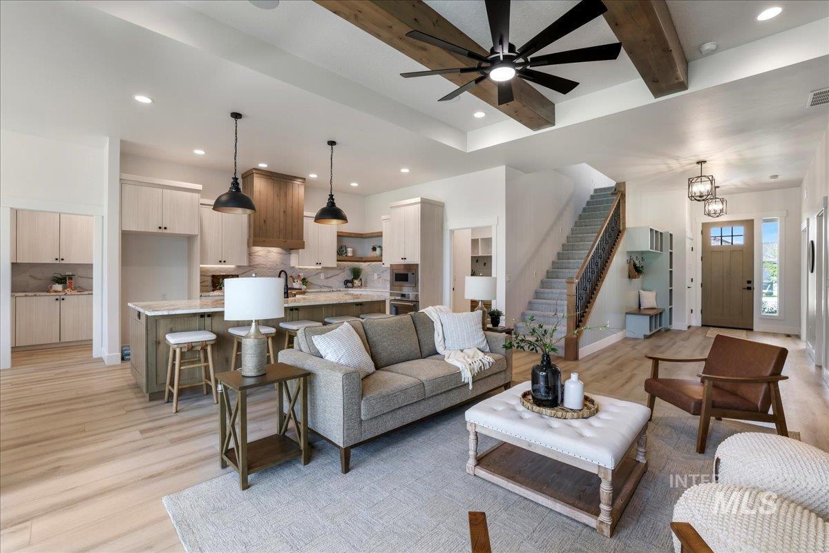 Living room with recessed lighting, light wood-style flooring, stairway, beam ceiling, and a ceiling fan