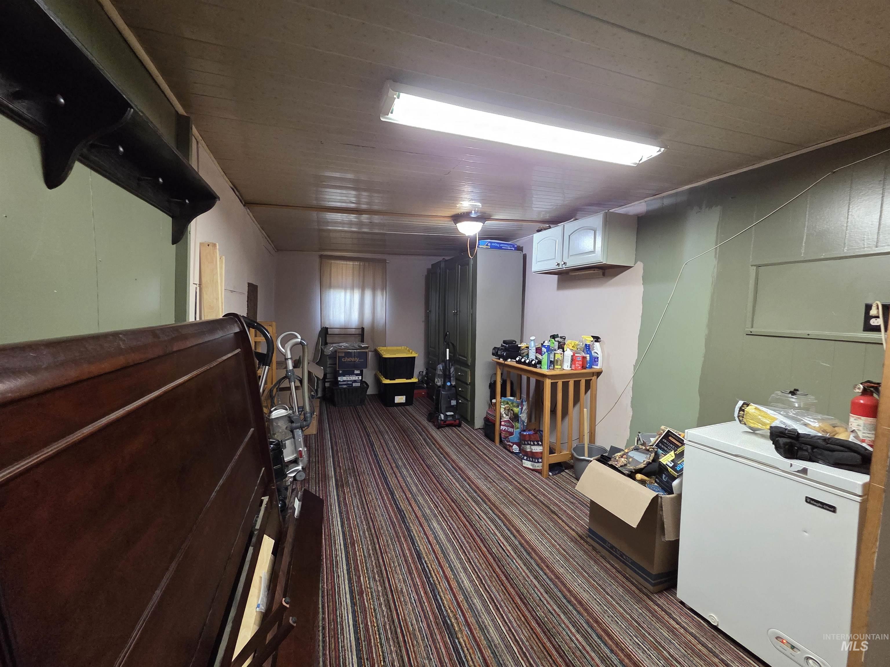 Finished below grade area with refrigerator and carpet flooring