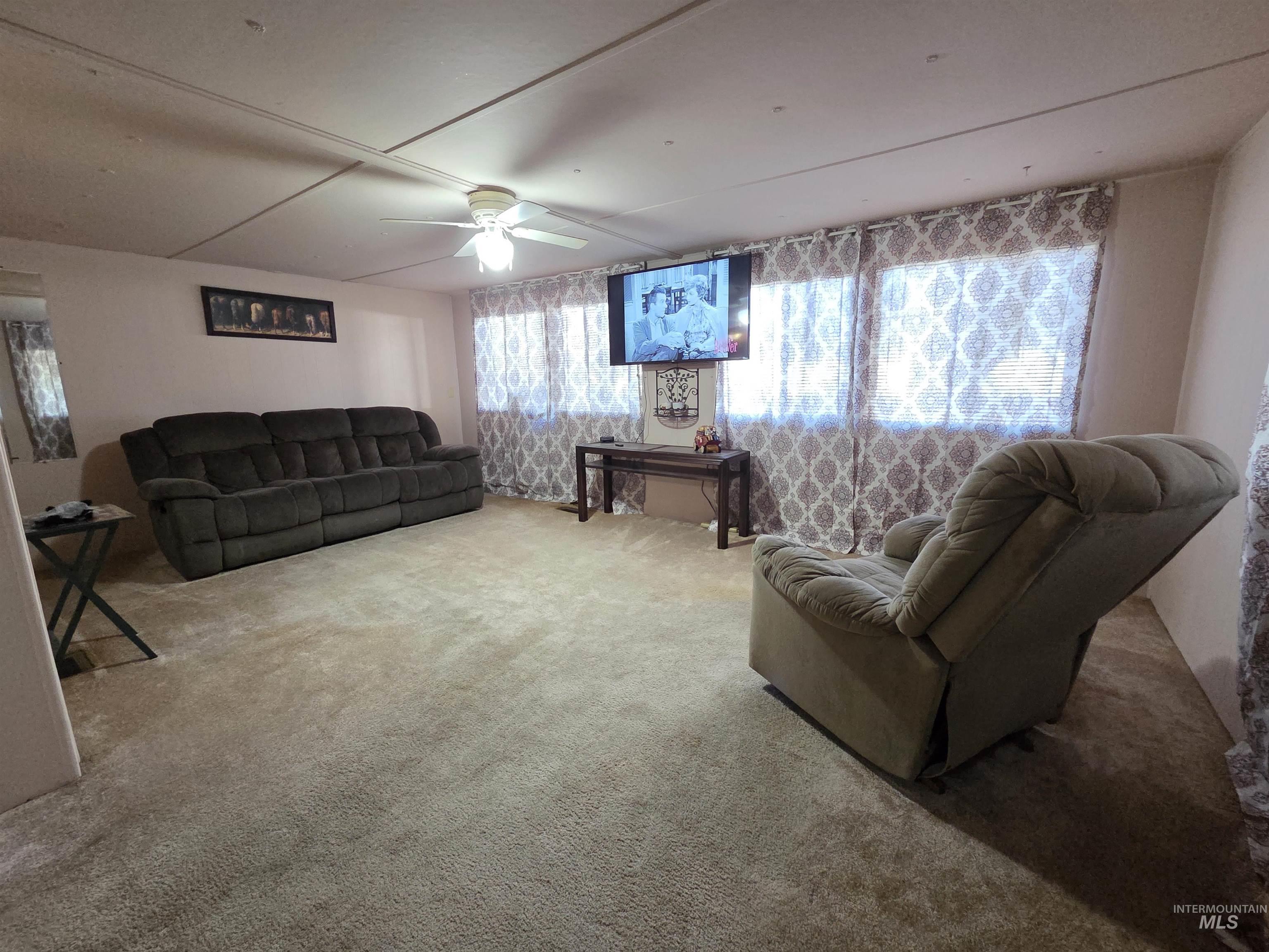 Living area with carpet flooring and a ceiling fan