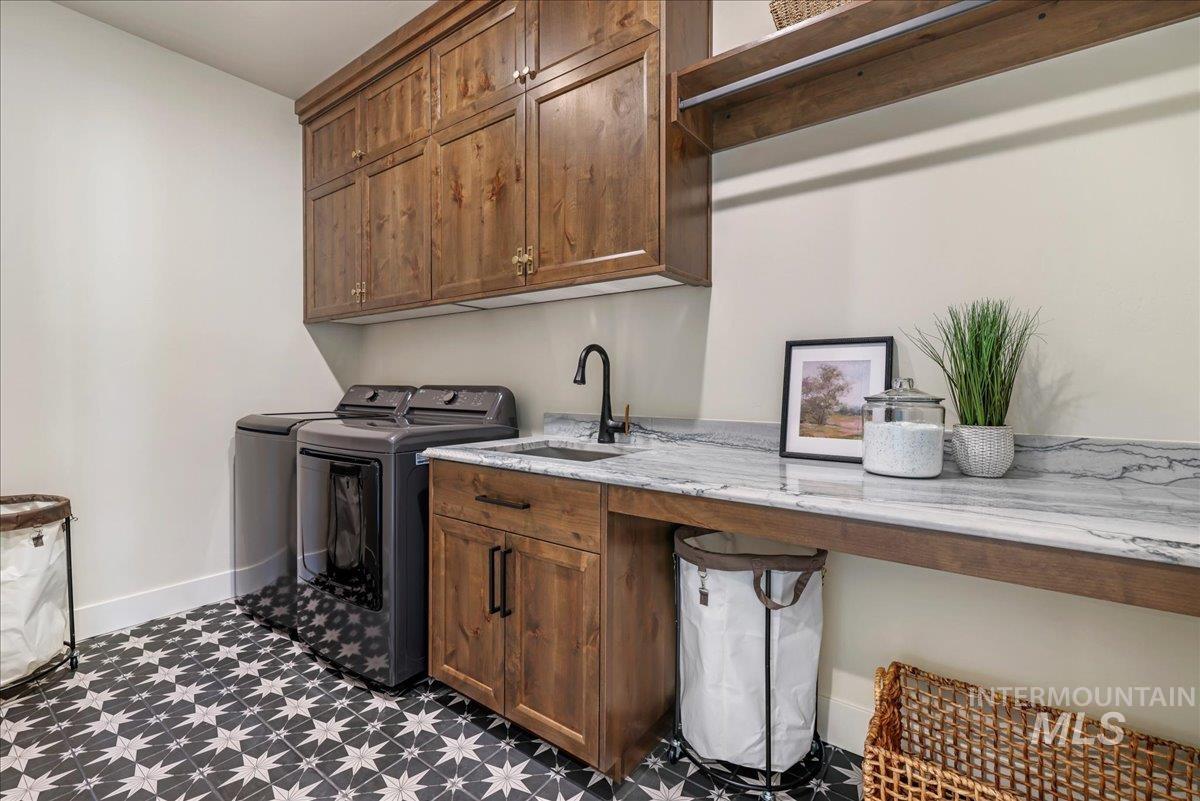 Laundry room featuring dark flooring, washer and clothes dryer, cabinet space, and an office area