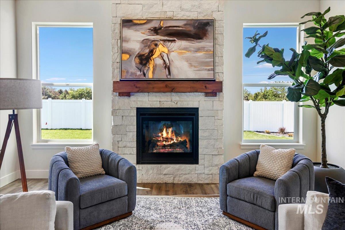 Living room featuring wood finished floors and a stone fireplace
