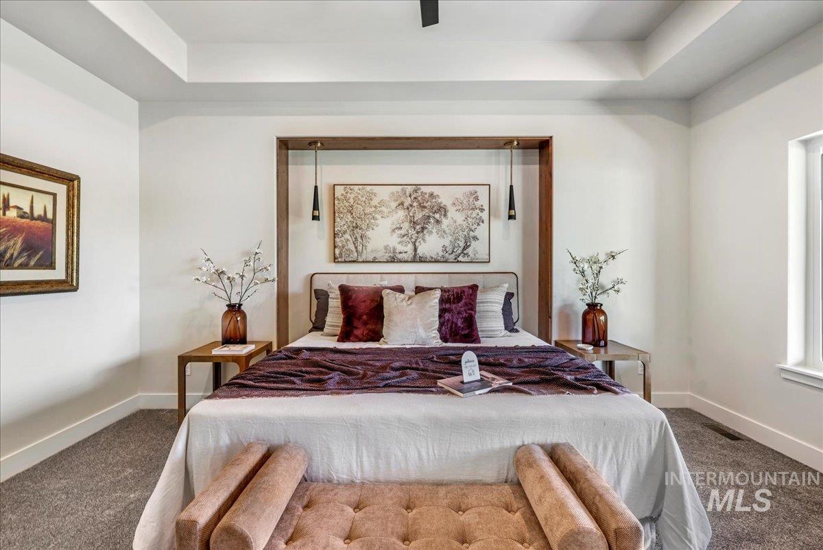 Carpeted bedroom featuring a raised ceiling