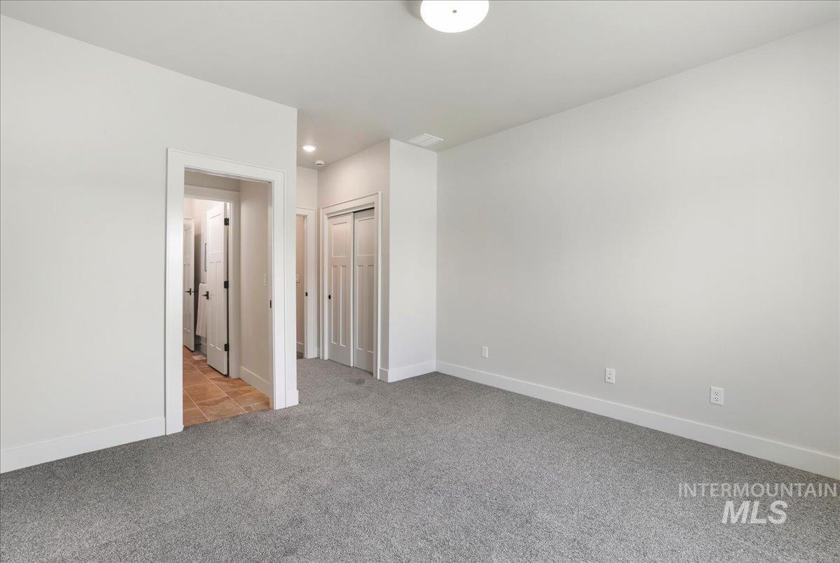 Unfurnished bedroom featuring light carpet, recessed lighting, and a closet