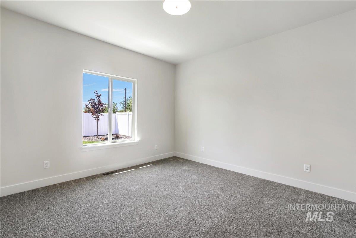 Unfurnished room featuring carpet and baseboards