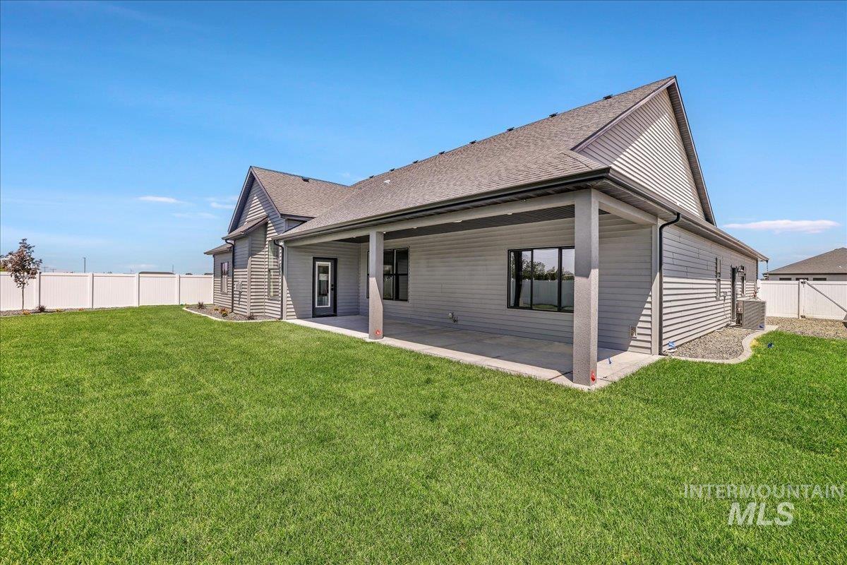 Back of property with a patio area, a fenced backyard, and a shingled roof