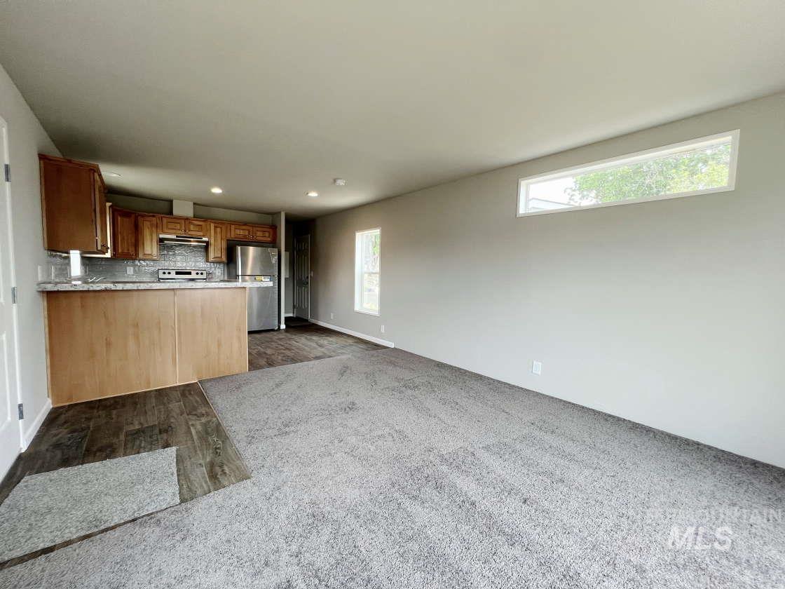 Kitchen with freestanding refrigerator, plenty of natural light, white electric stove, decorative backsplash, and recessed lighting