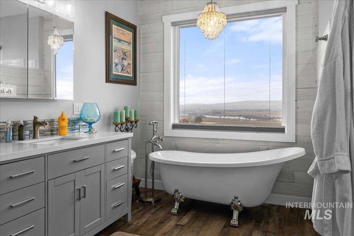 Bathroom with a chandelier, healthy amount of natural light, vanity, and wood finished floors