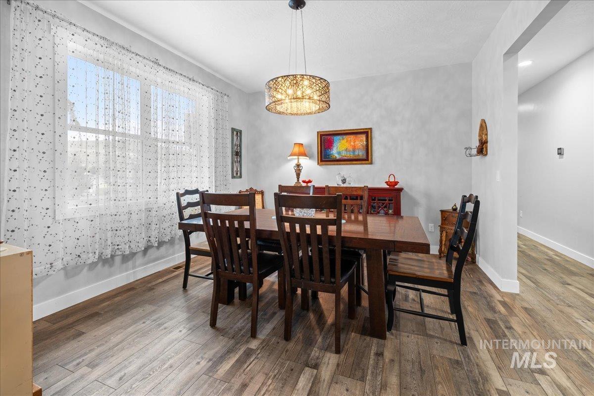 Dining area with wood finished floors and a chandelier