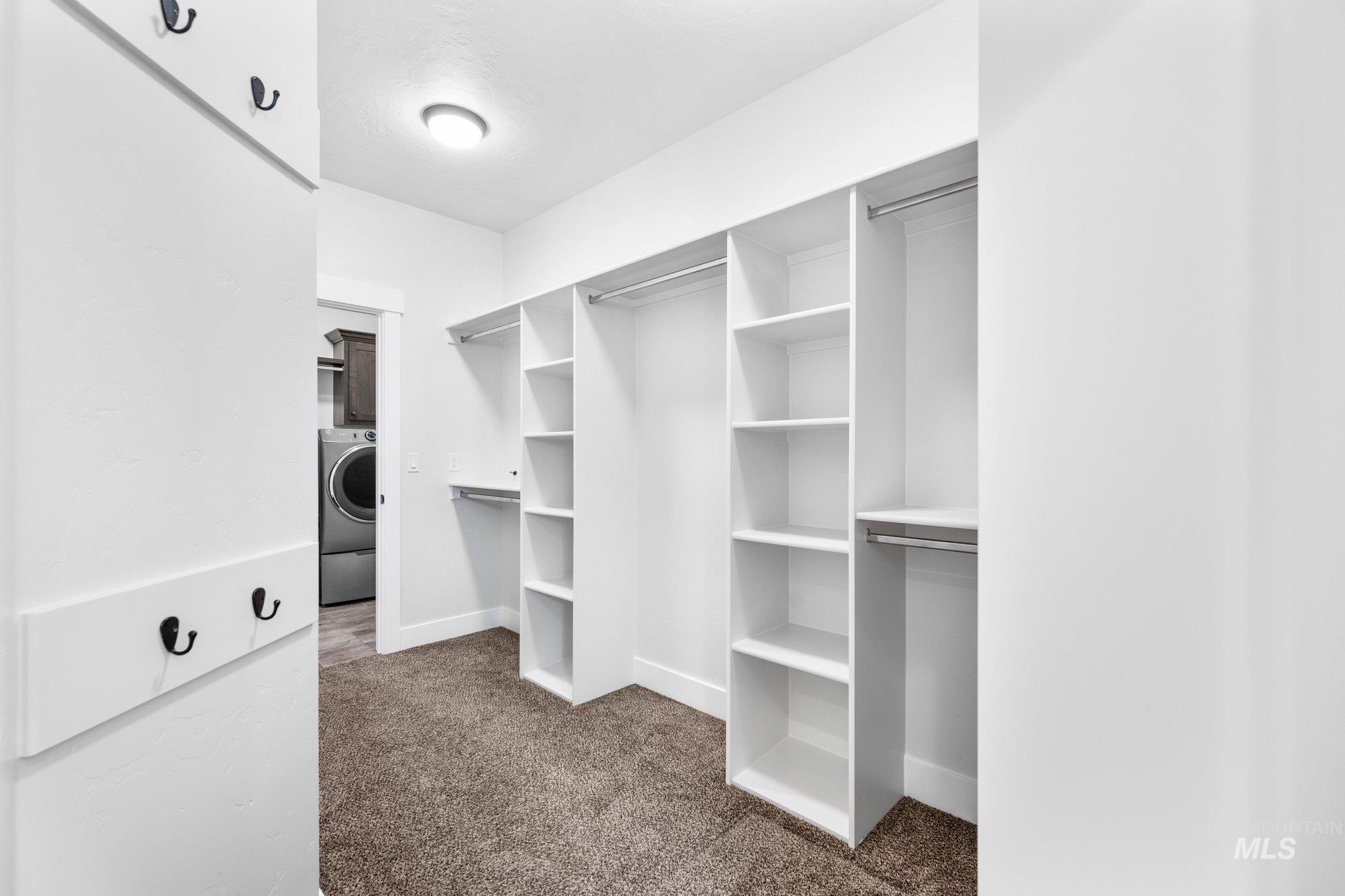 Walk in closet with carpet flooring and washer / clothes dryer