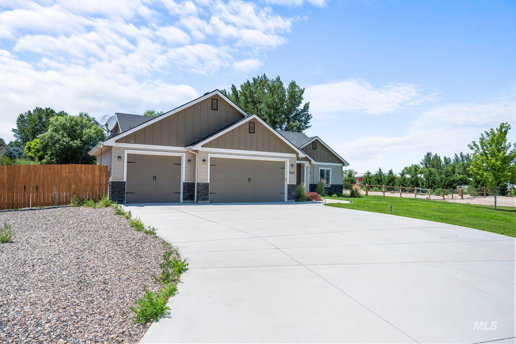 Craftsman house featuring board and batten siding, an attached garage, driveway, and stone siding