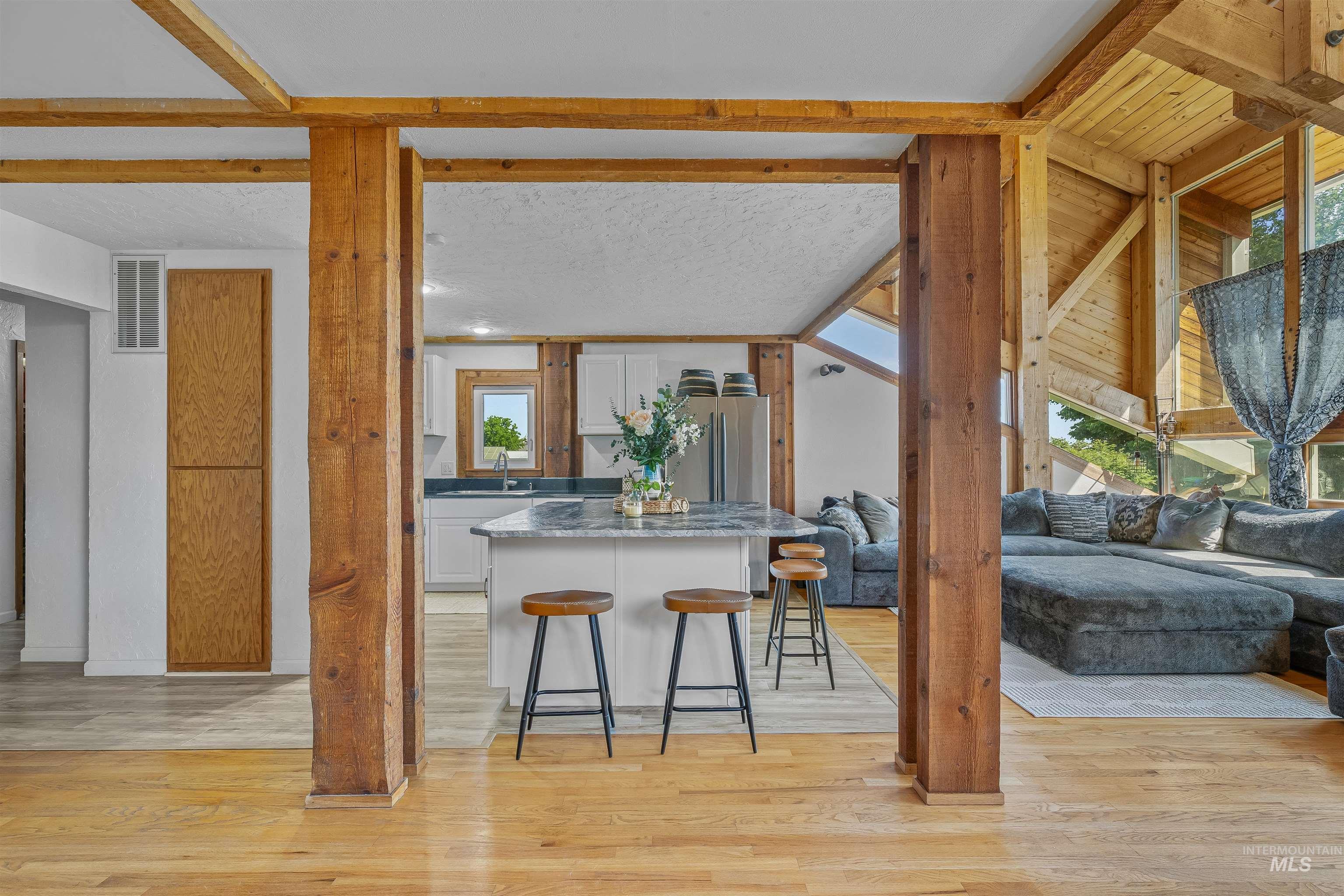 Kitchen featuring a kitchen breakfast bar, open floor plan, white cabinets, and plenty of natural light