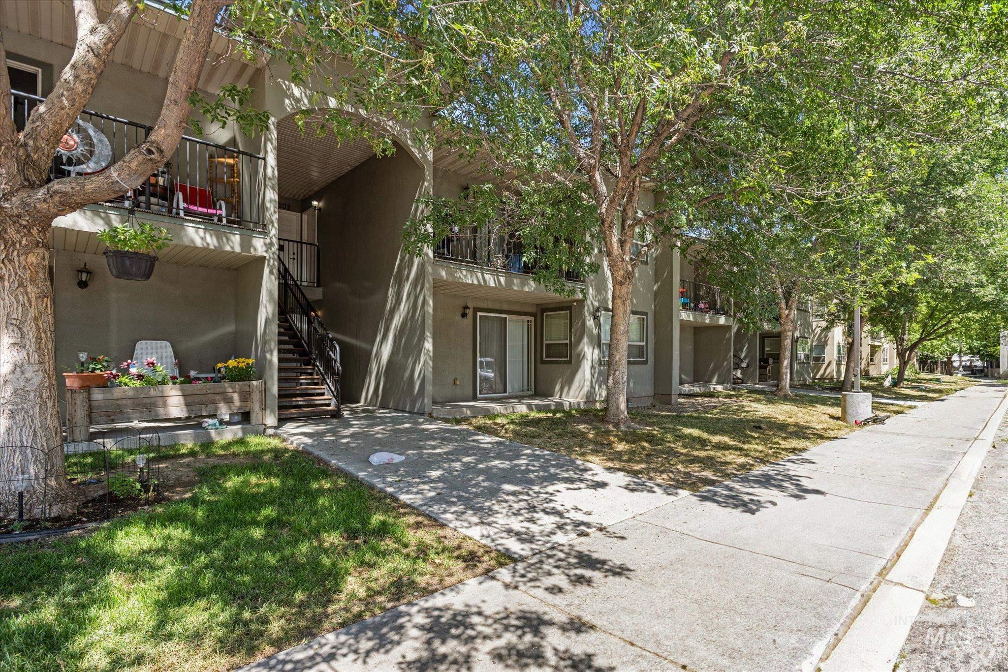 View of front of house with stairway, a balcony, and stucco siding