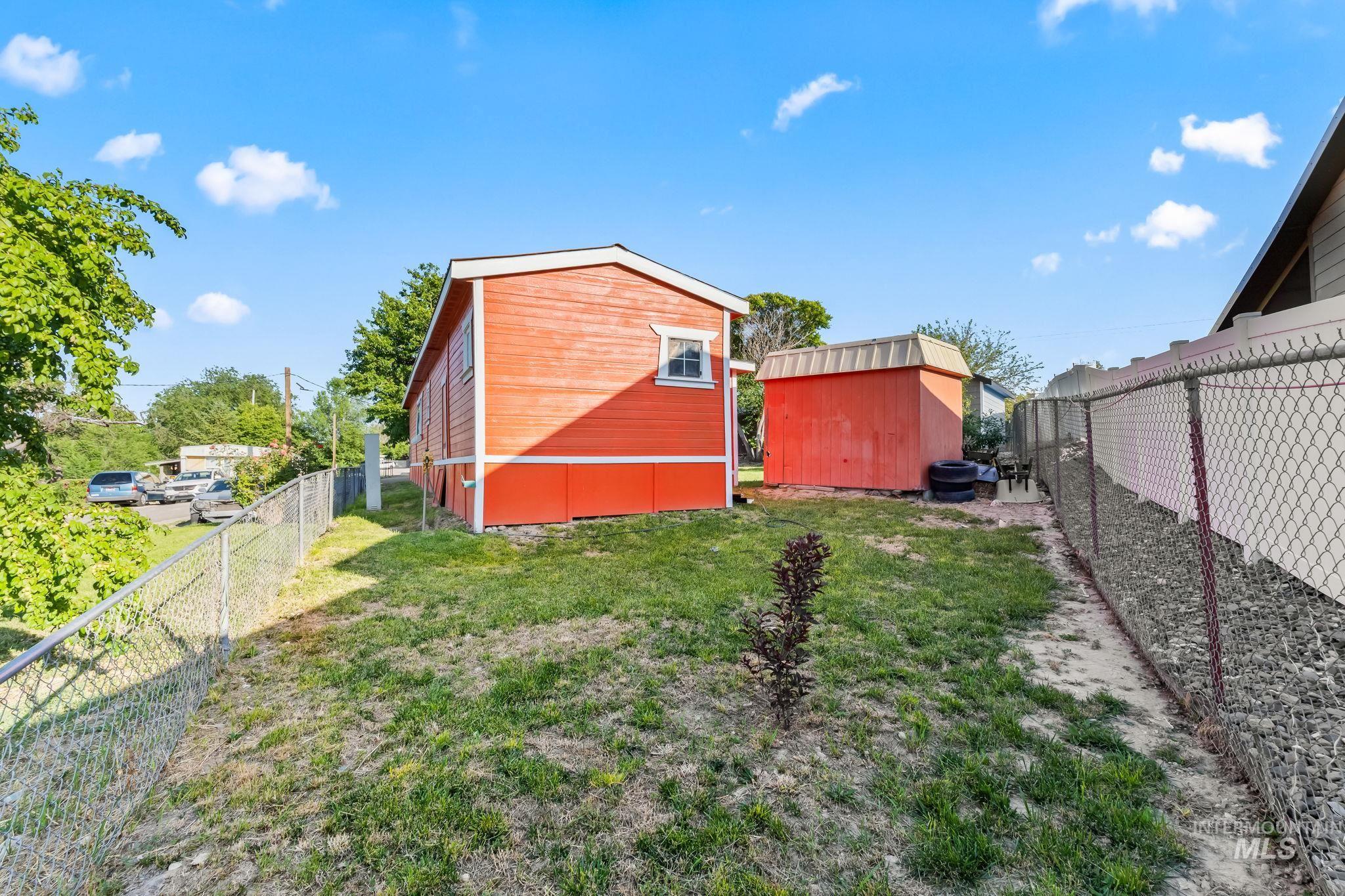 Fenced backyard featuring a storage unit