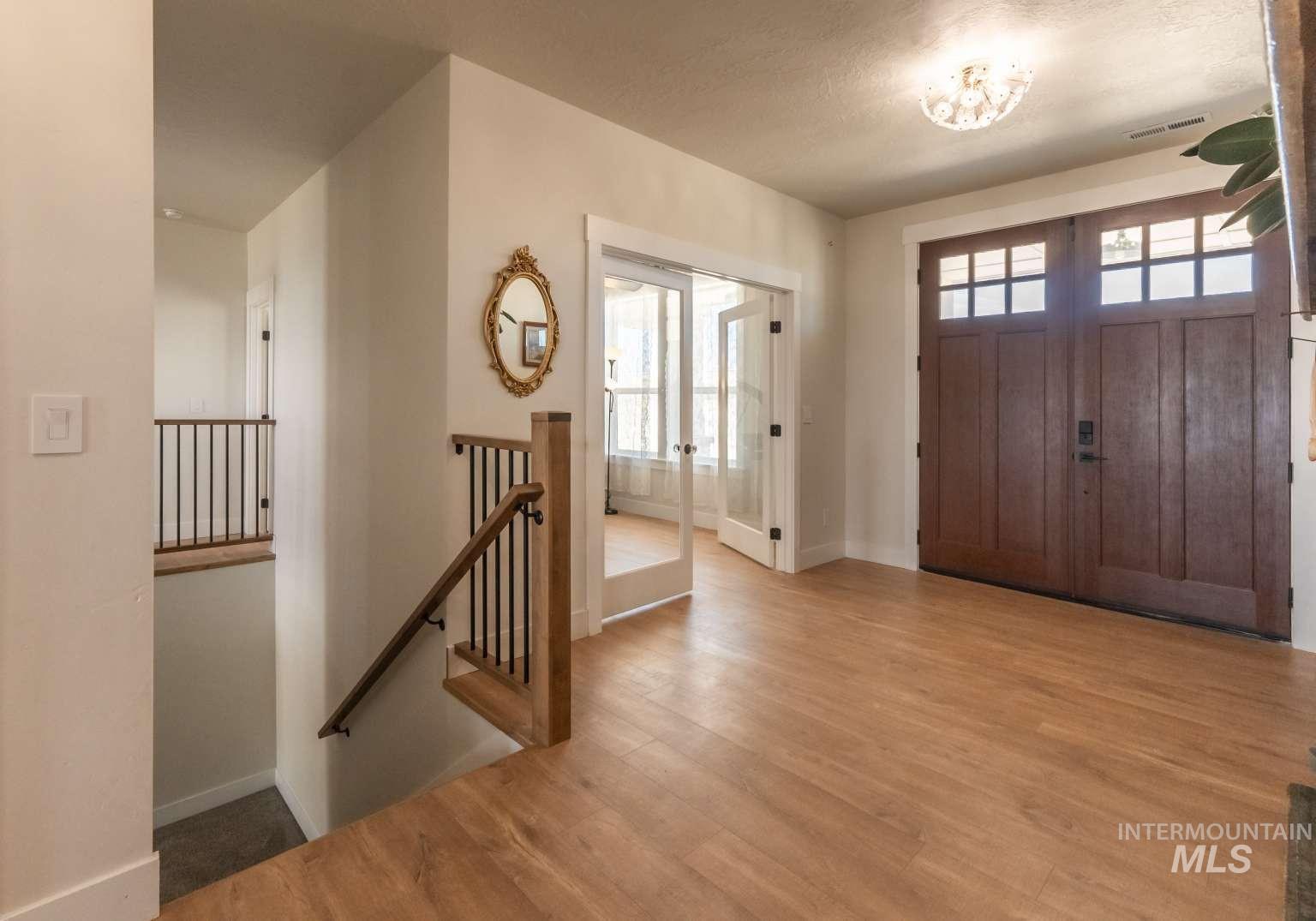 Foyer entrance featuring wood finished floors and french doors