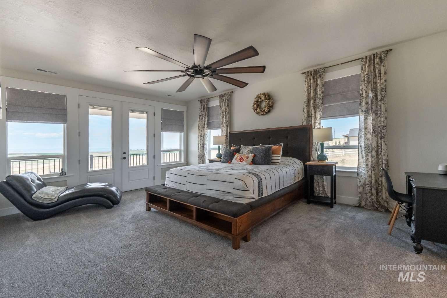 Bedroom with access to outside, multiple windows, and carpet flooring