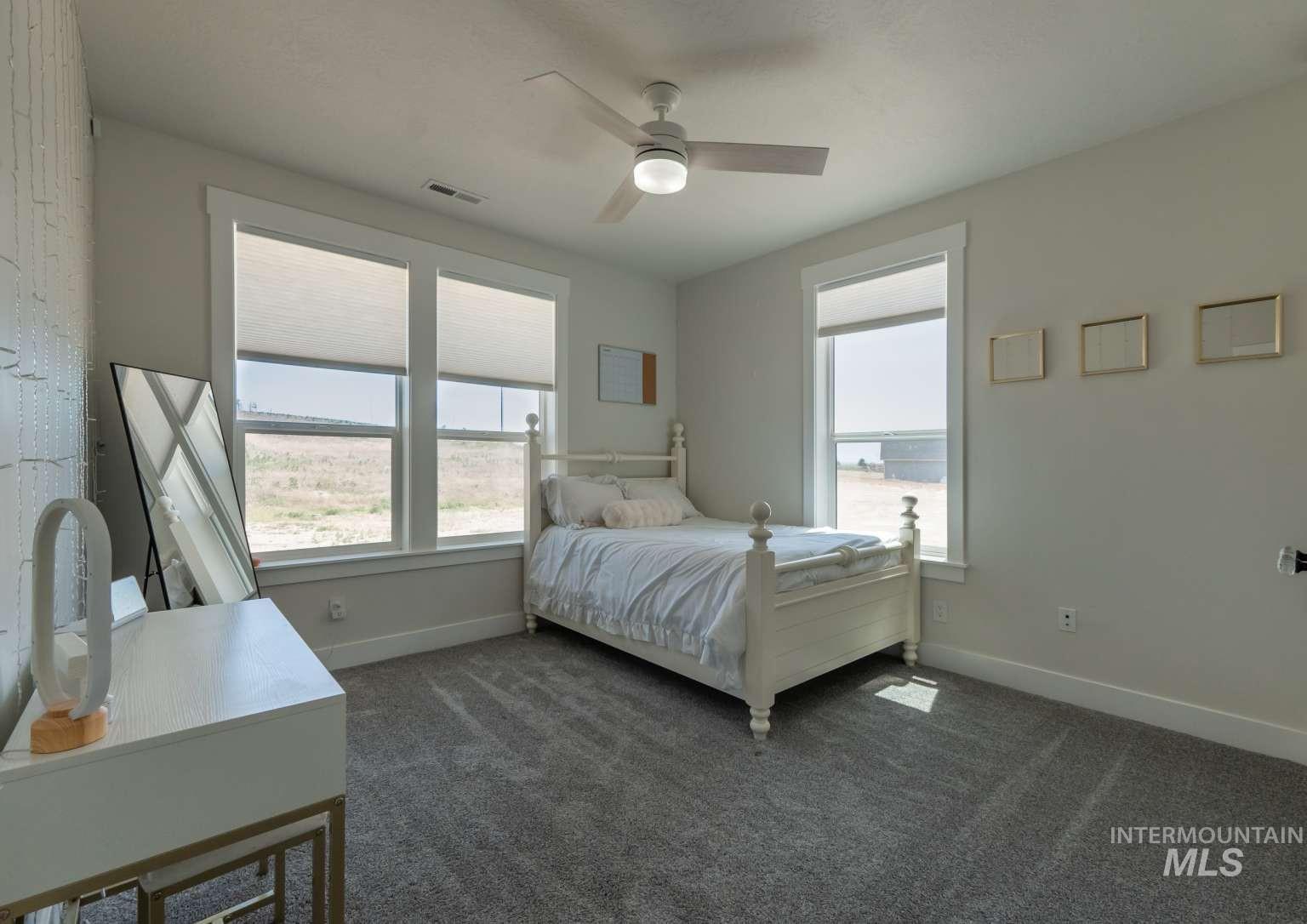 Bedroom featuring dark carpet and ceiling fan