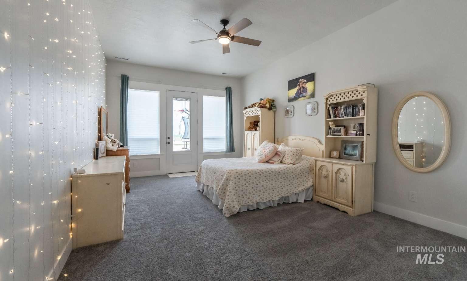 Carpeted bedroom featuring access to exterior and ceiling fan