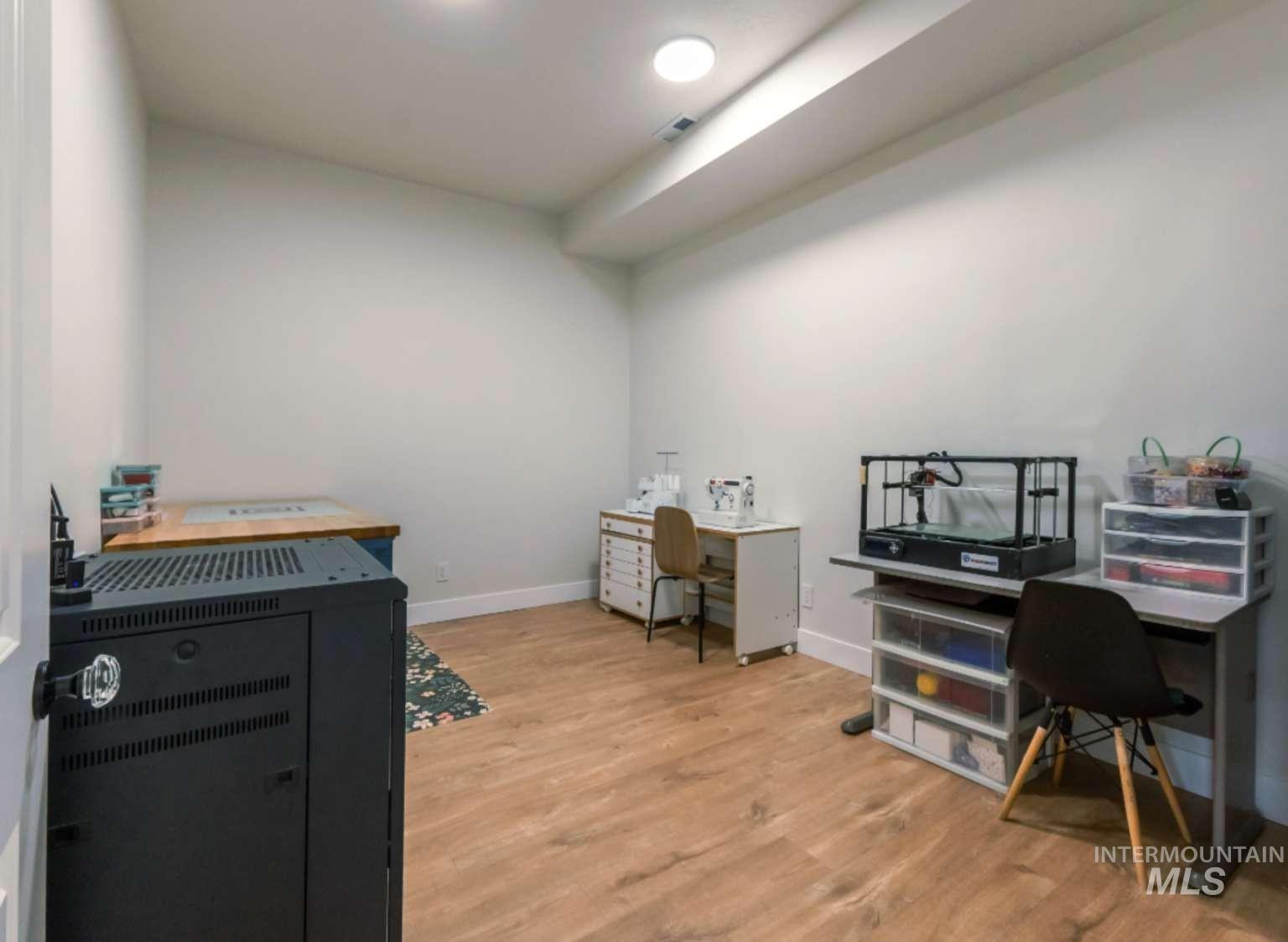Home office with light wood-style flooring and baseboards