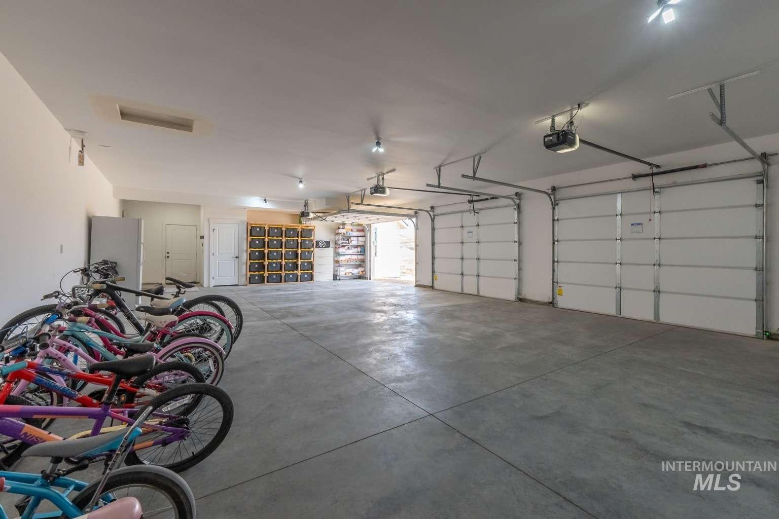 Garage featuring a garage door opener and freestanding refrigerator