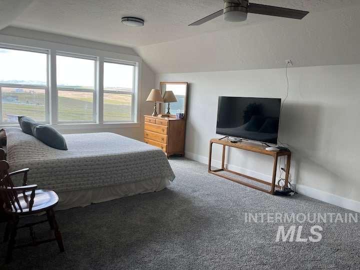 Bedroom with vaulted ceiling, carpet floors, and ceiling fan