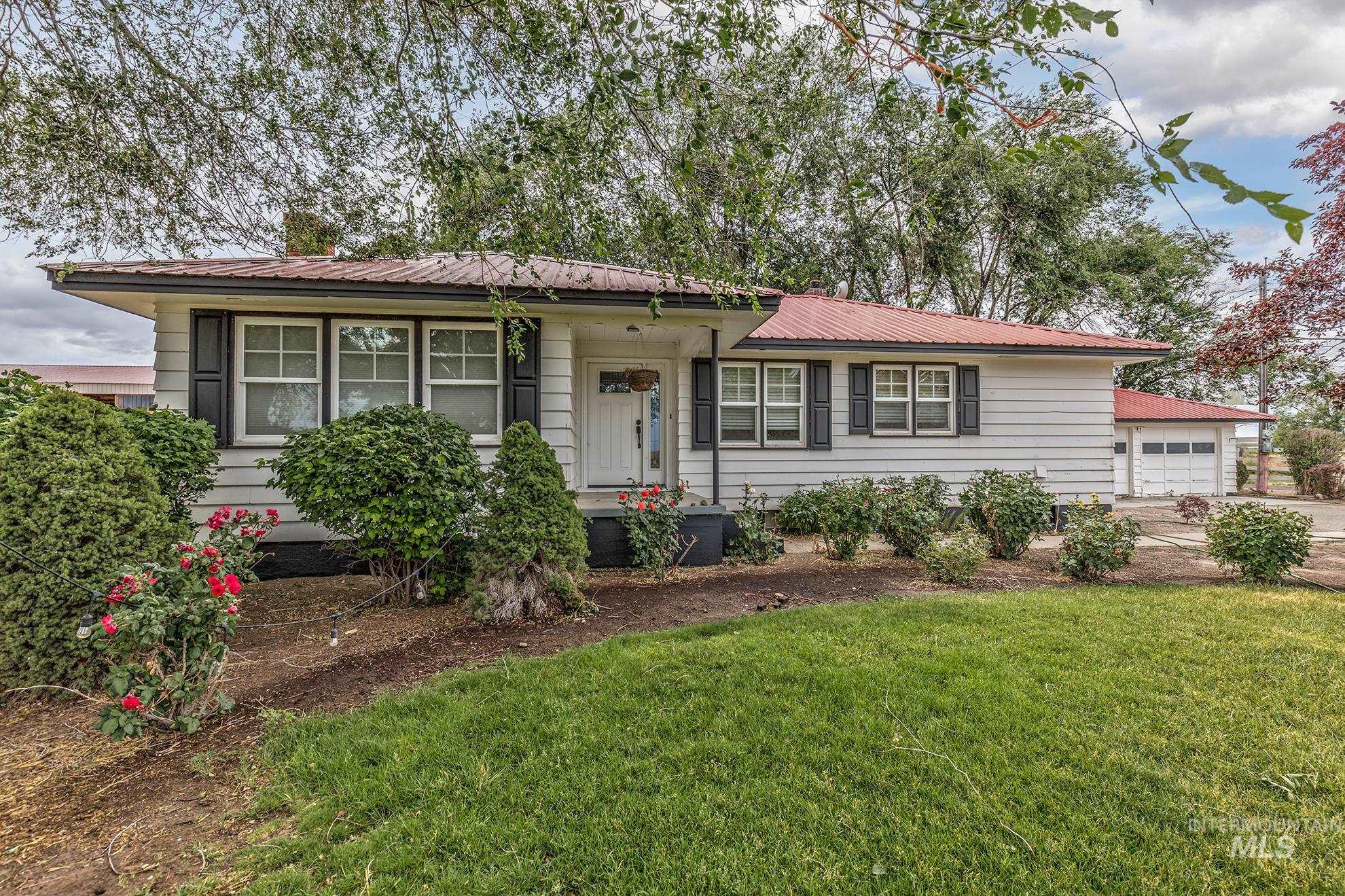 Ranch-style house featuring a metal roof, a front yard, and driveway