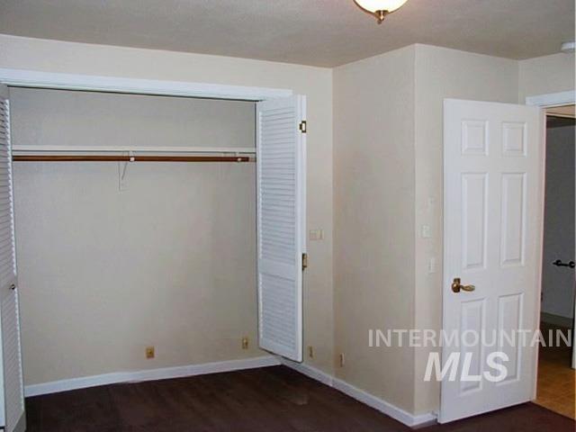 Unfurnished bedroom featuring a closet and baseboards