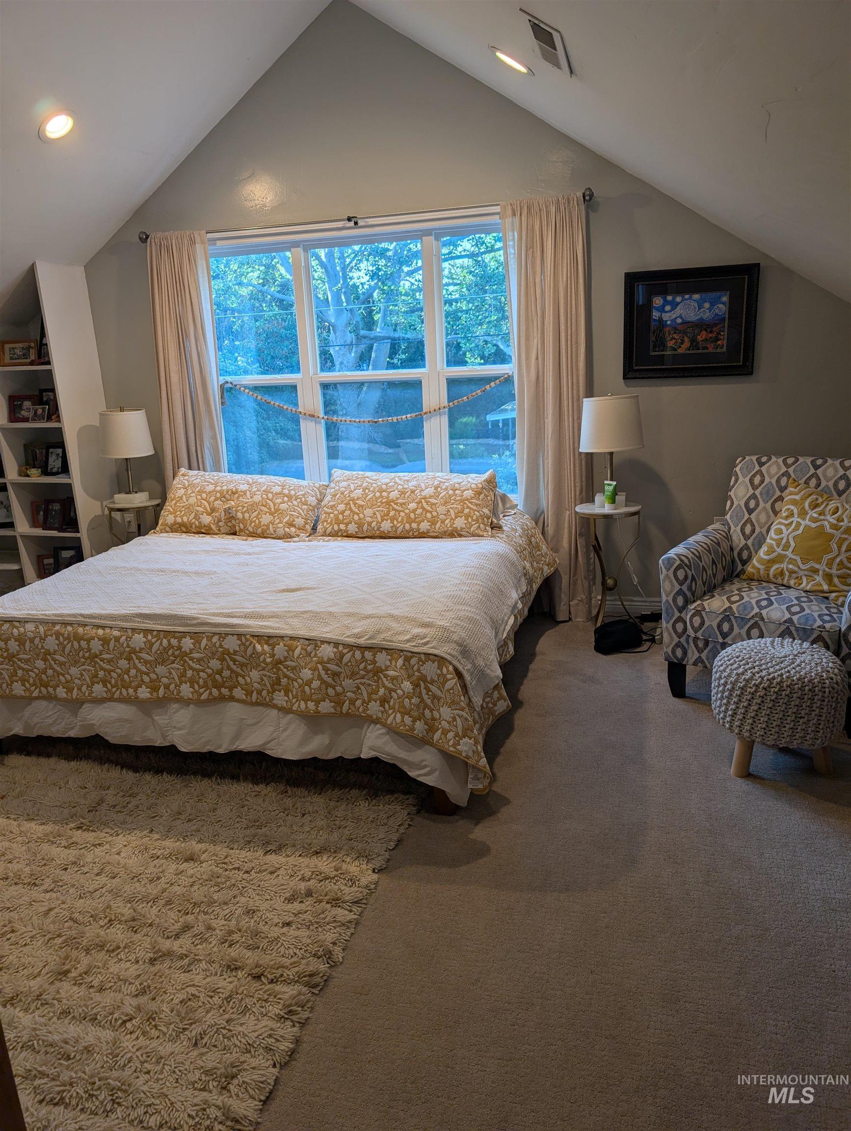 Carpeted bedroom with vaulted ceiling, multiple windows, and recessed lighting