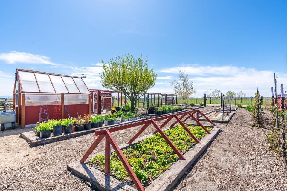 View of yard with a greenhouse, a garden, and an outdoor structure