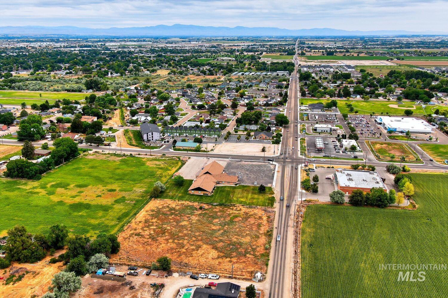 Aerial view of property and surrounding area with a mountainous background