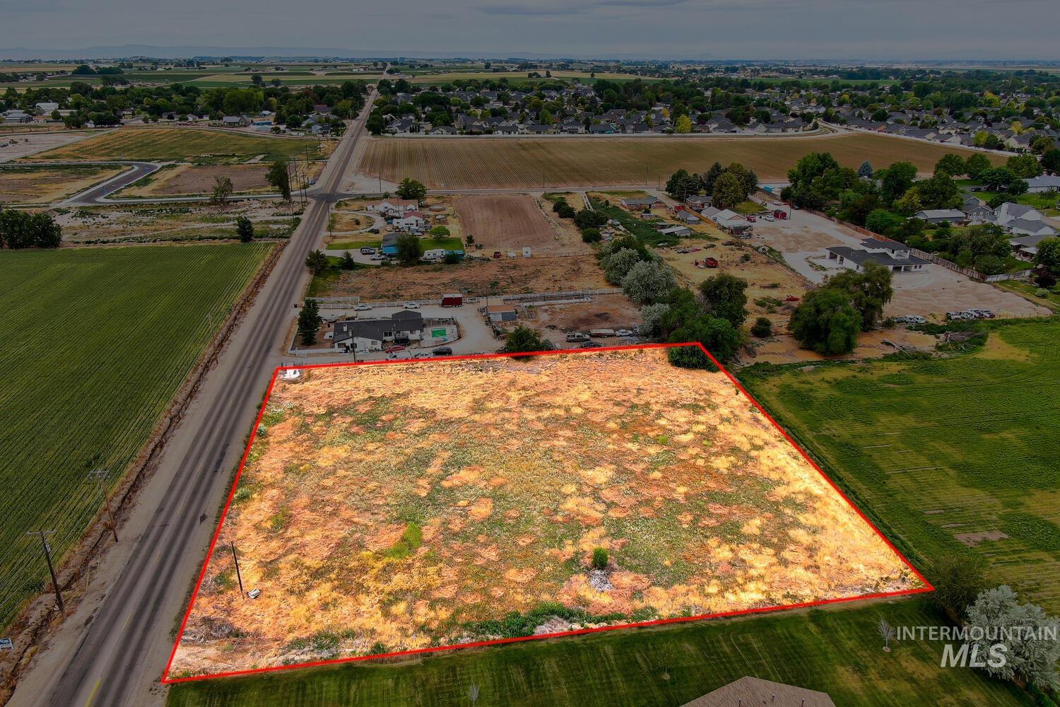 Aerial view of sparsely populated area with property parcel outlined and extensive farmland