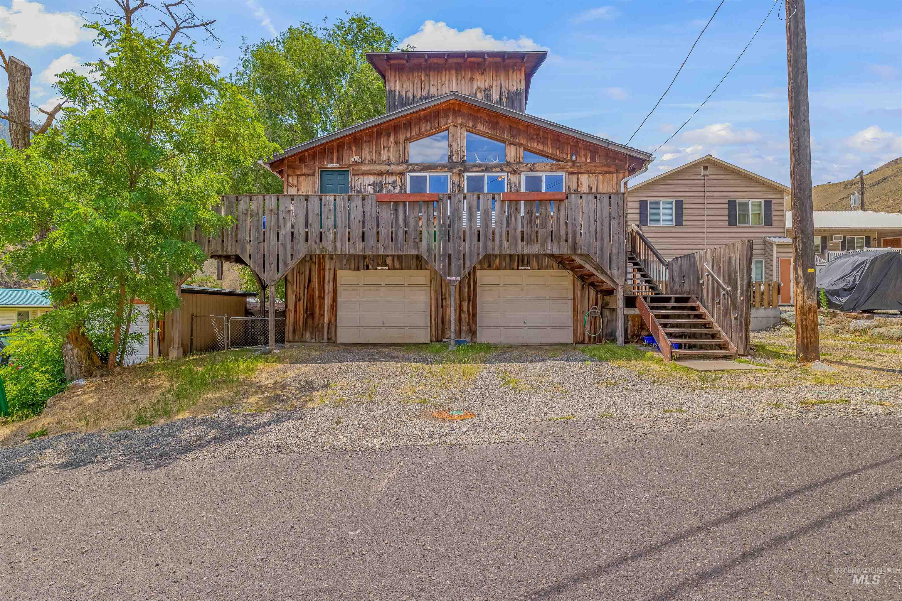 View of front of home with stairs, an attached garage, and driveway