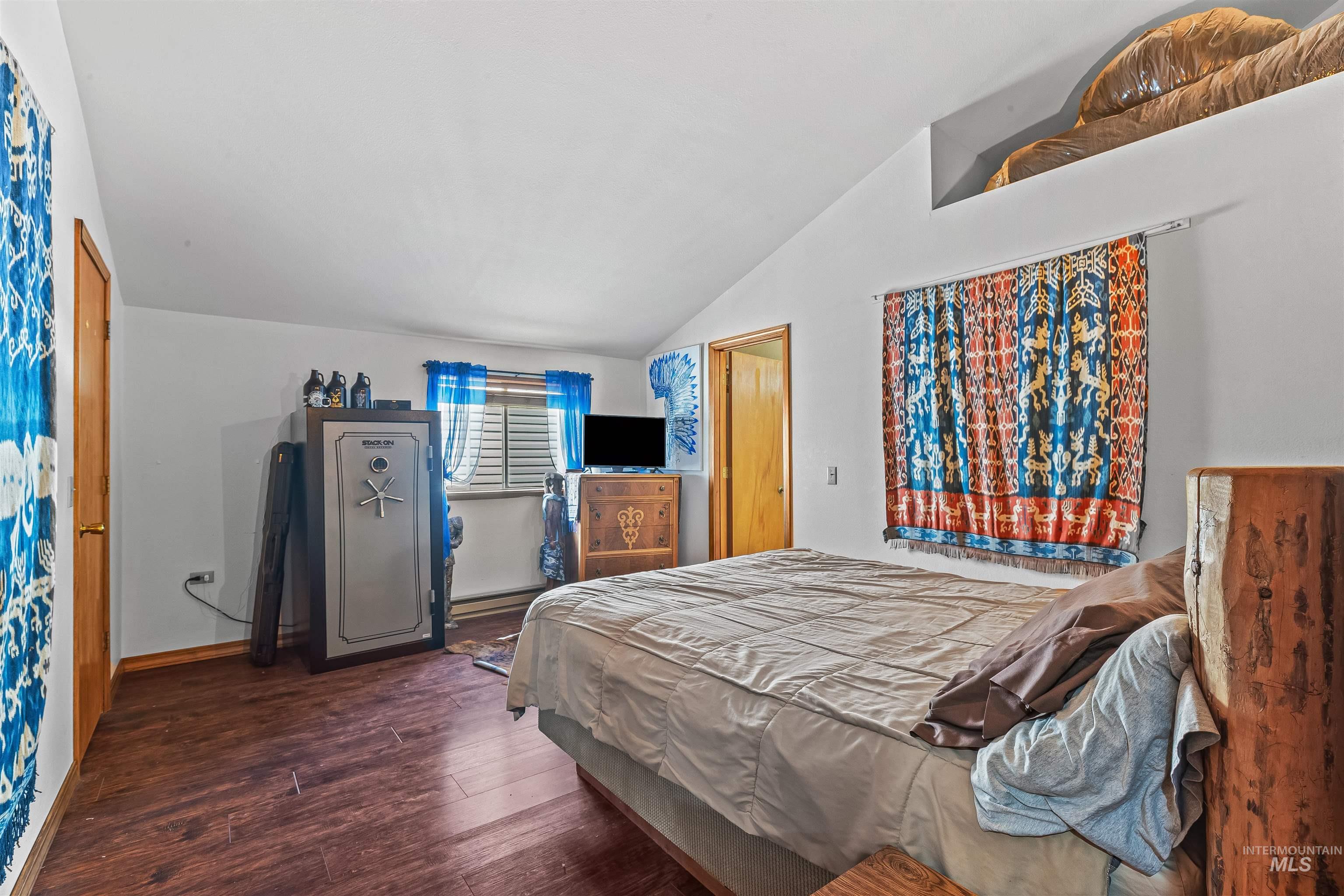 Bedroom featuring vaulted ceiling and wood finished floors