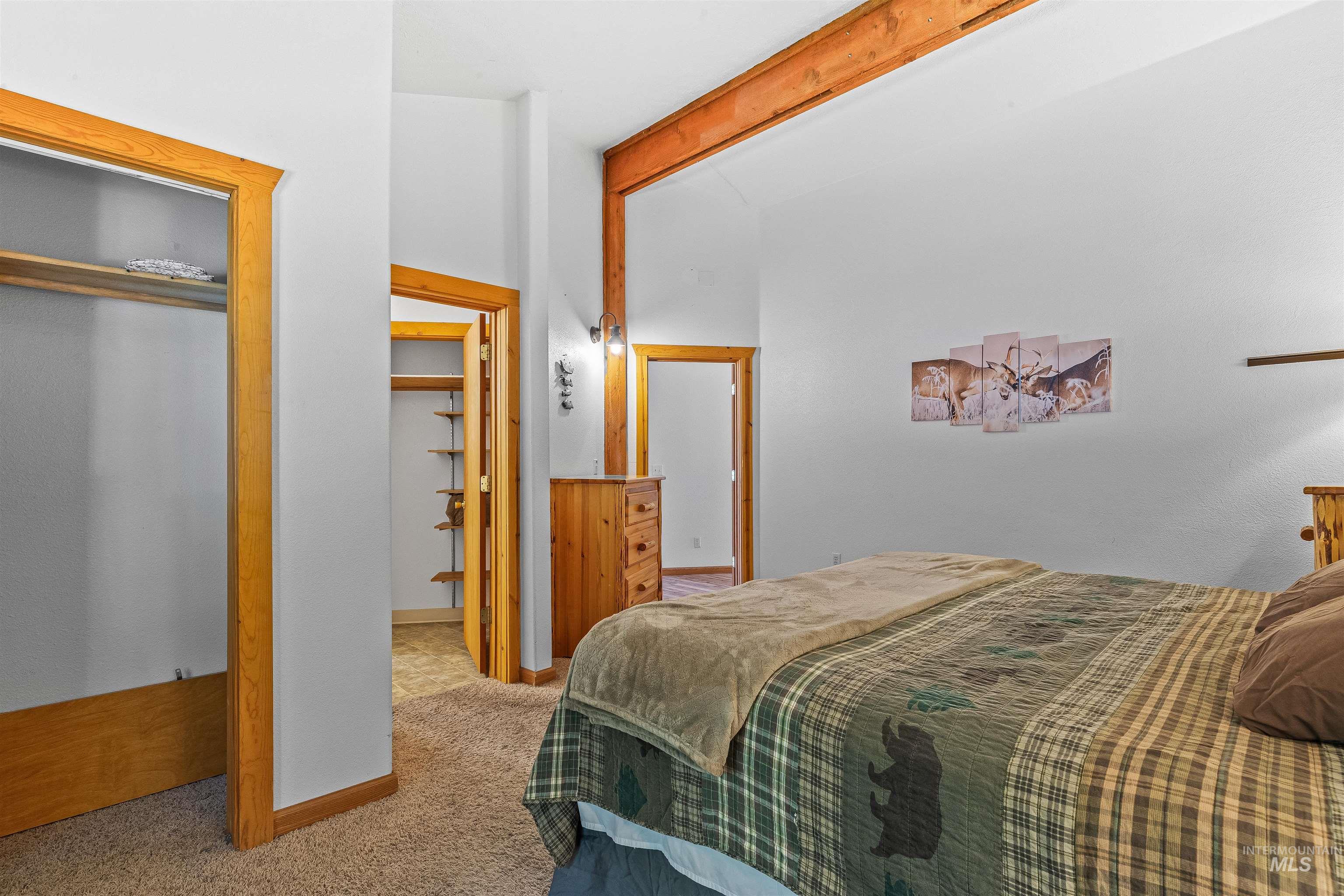 Bedroom with carpet, beamed ceiling, and a closet