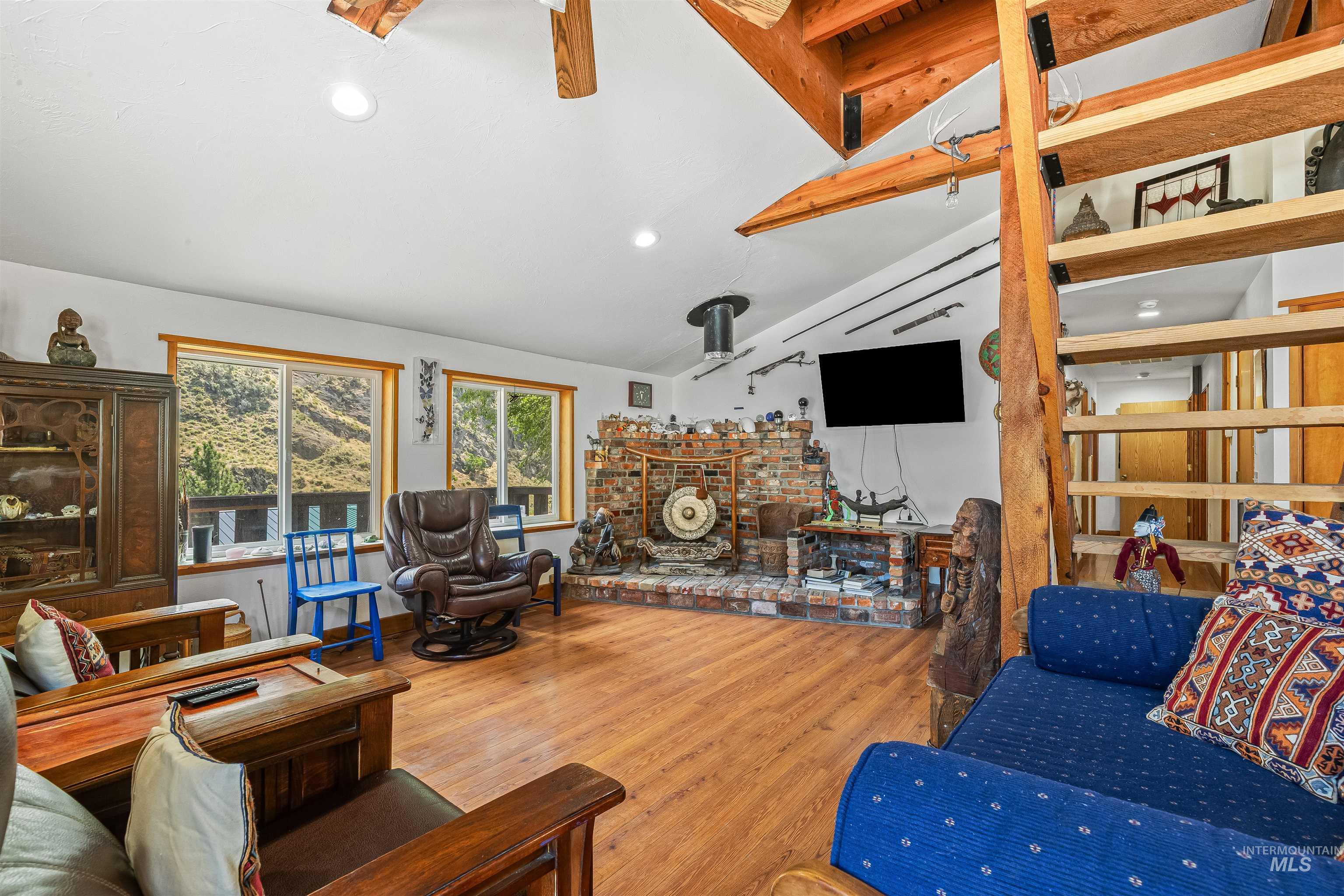 Living area featuring wood finished floors, a wood stove, and recessed lighting