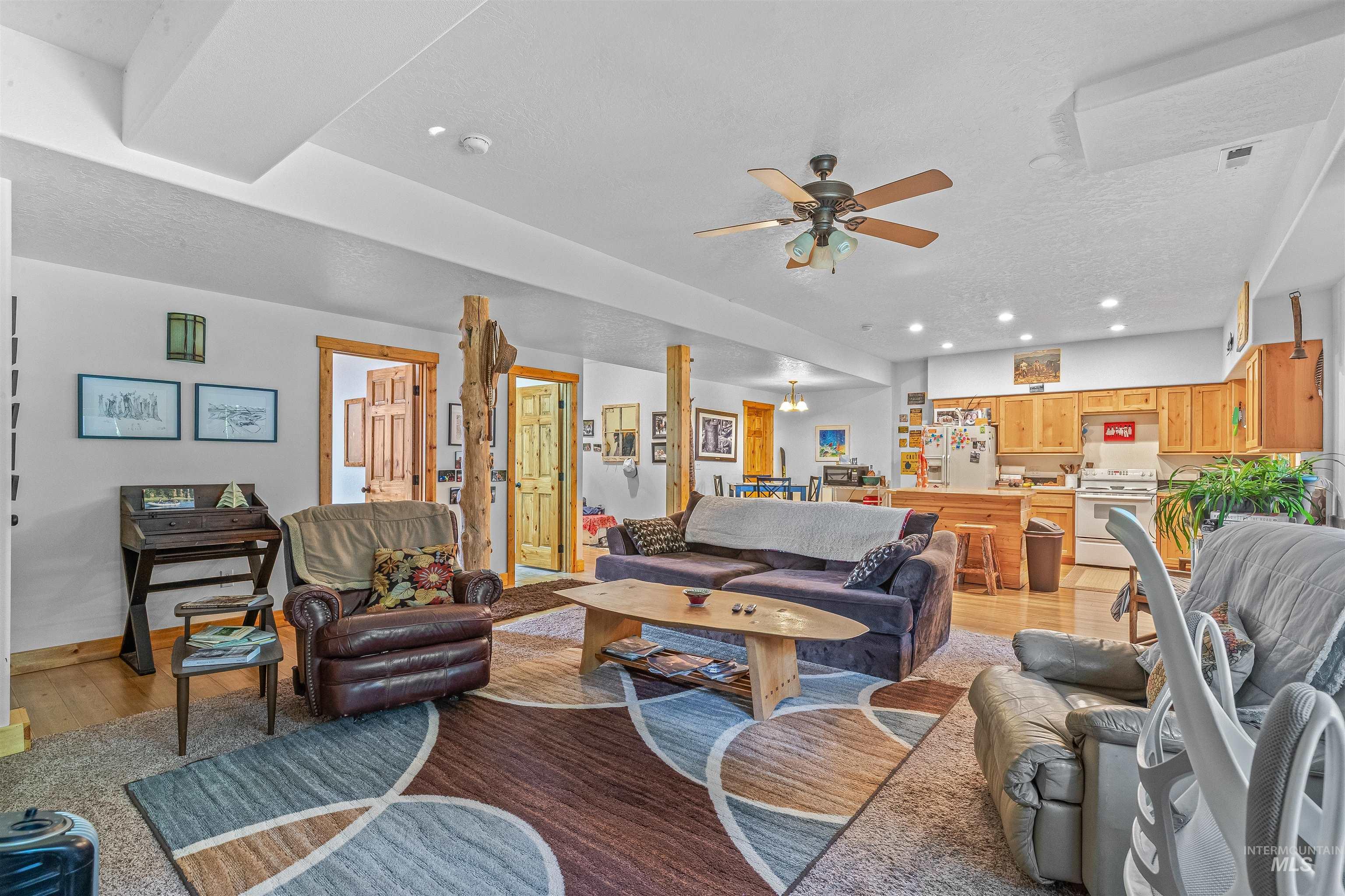 Living area with ceiling fan, light wood-type flooring, recessed lighting, and a textured ceiling