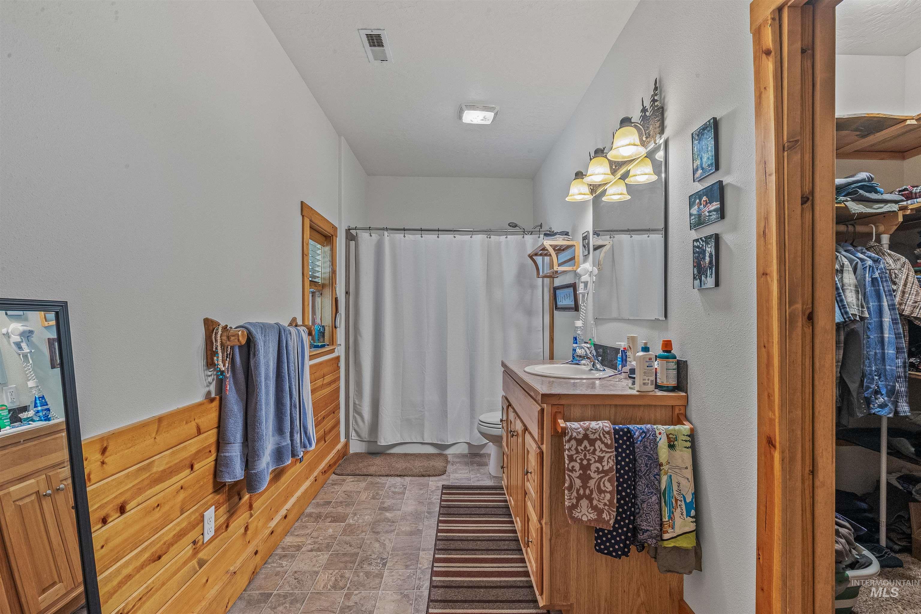 Full bathroom featuring vanity, curtained shower, and a walk in closet
