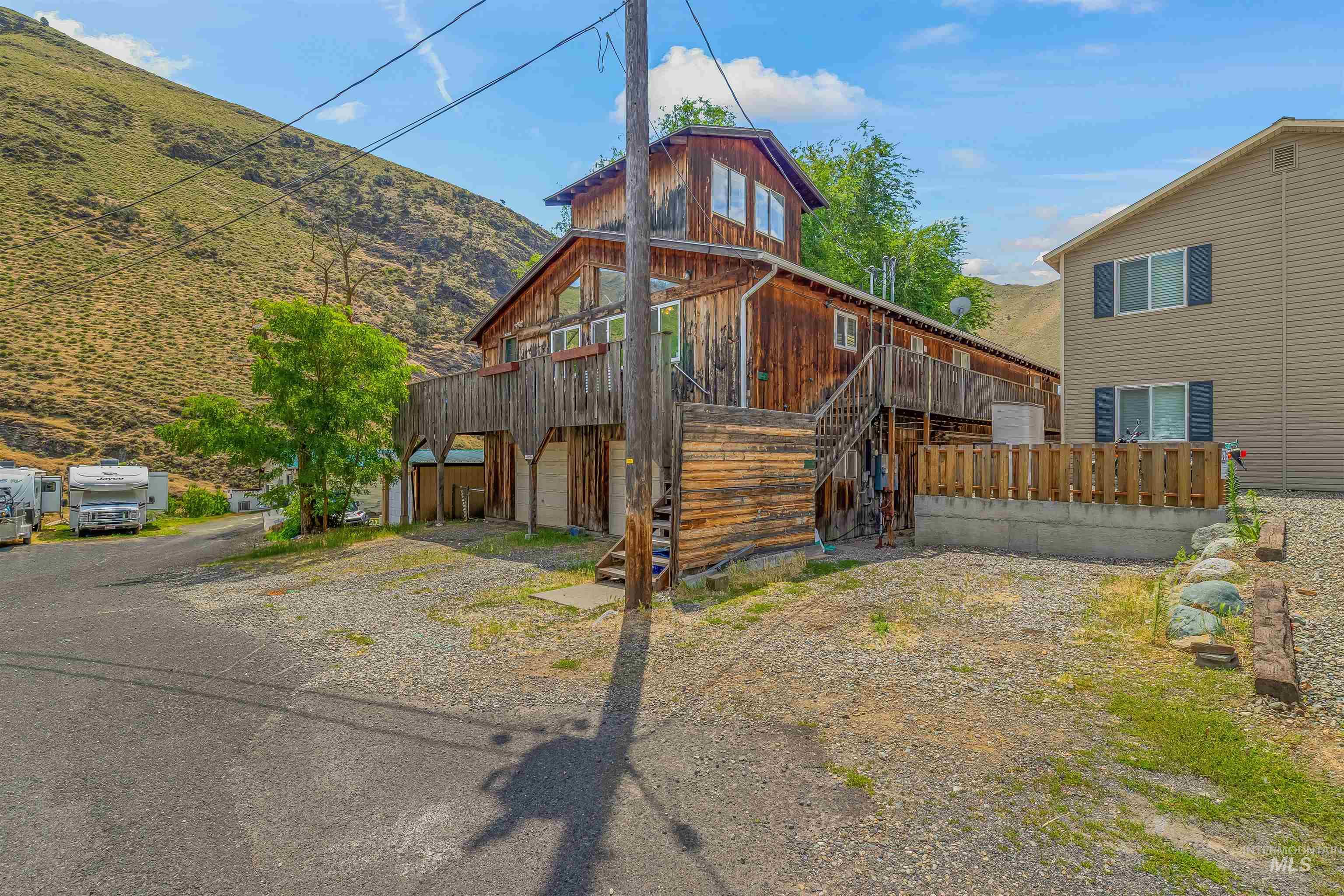 View of front of property with a mountain view, driveway, and stairway