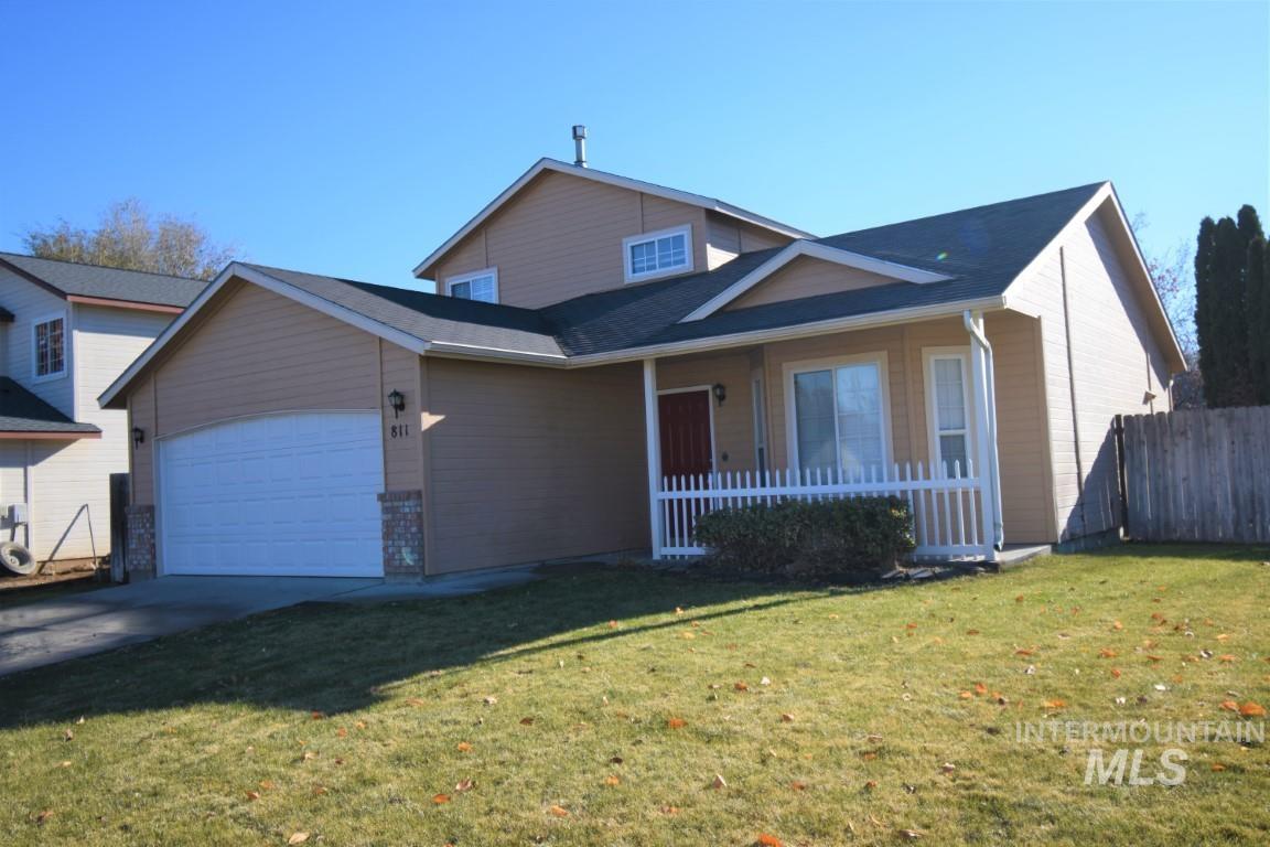 Traditional home with a garage, driveway, and covered porch