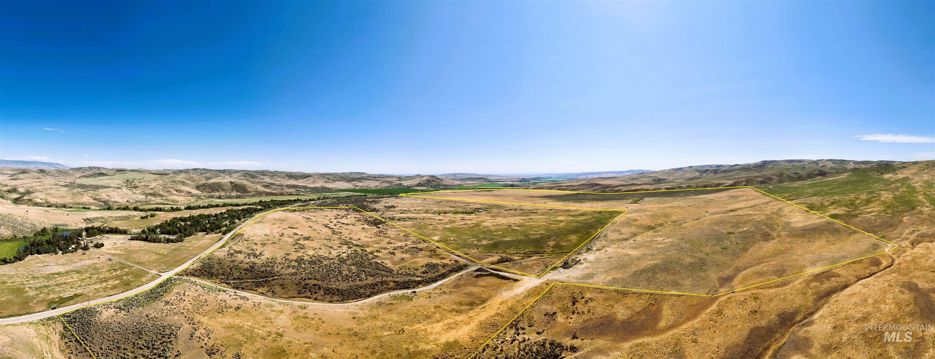 Aerial view of property and surrounding area featuring property parcel outlined and a mountain backdrop