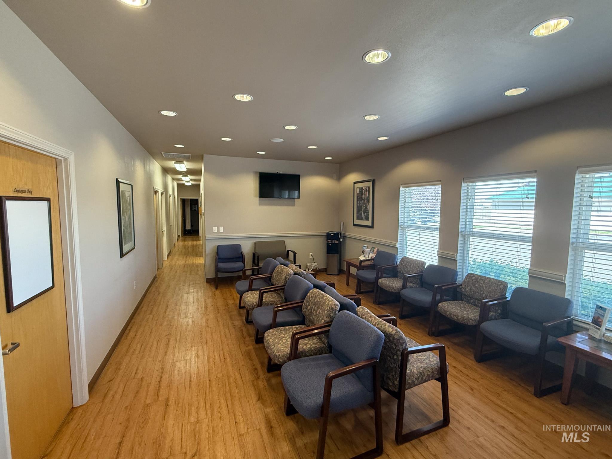 Living area featuring light wood finished floors and recessed lighting