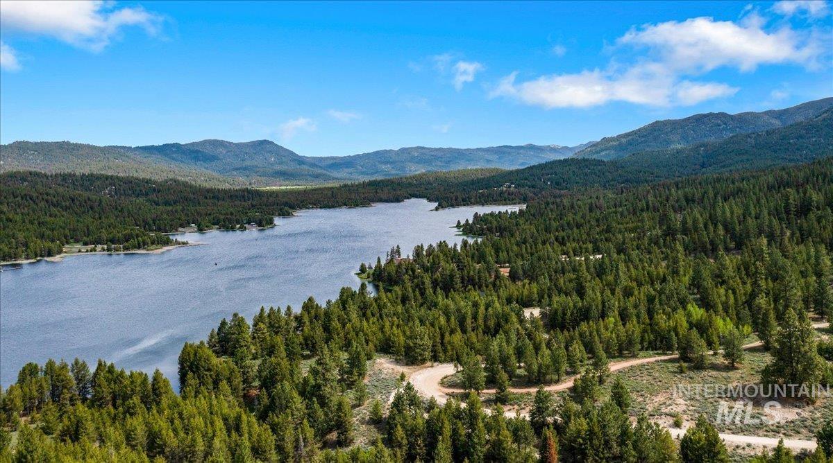 View of mountain background featuring a heavily wooded area and a large body of water